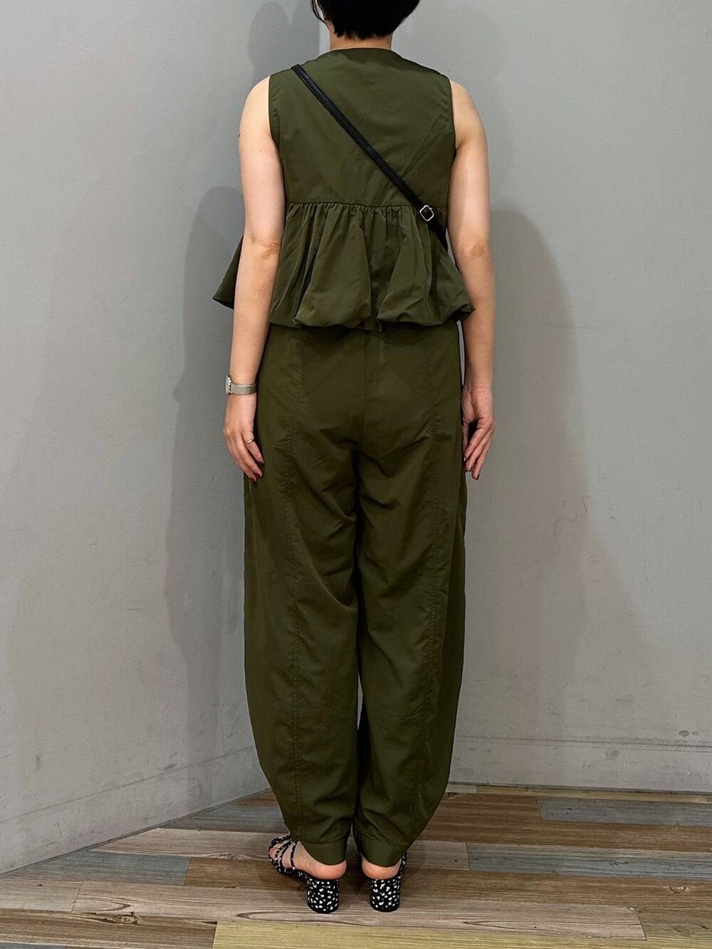 ブラック系のショルダーバッグ、ブラック系のサンダル、ブラック系のキャミソールを着用したレディースの夏コーディネートの2枚目の写真