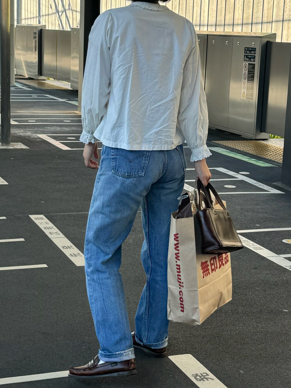 ブラウン系のローファー、ブルー系のデニムパンツを着用したレディースの秋コーディネートの2枚目の写真