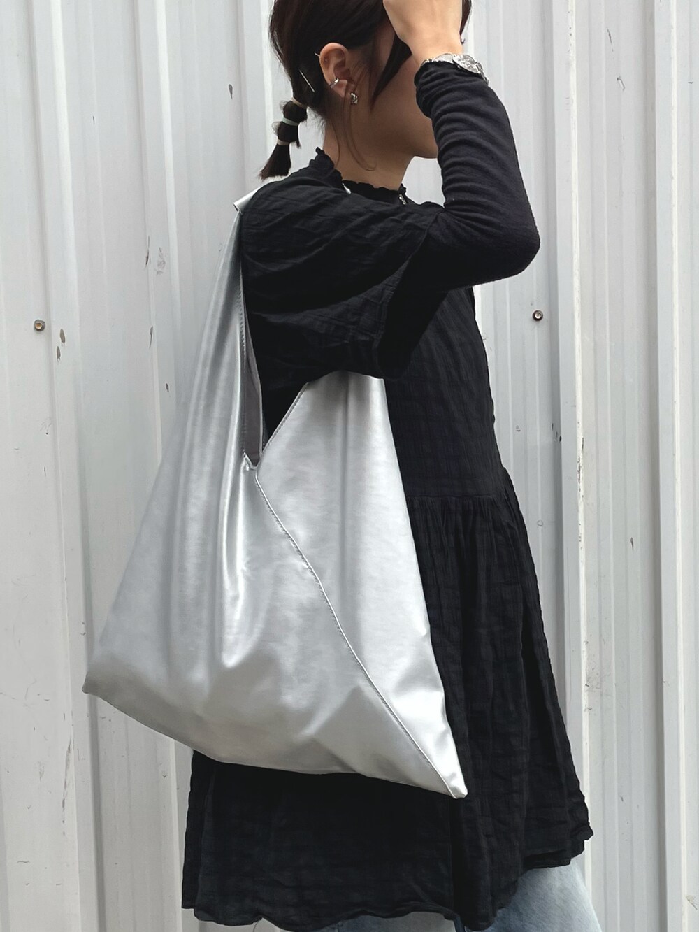 ホワイト系のスニーカー、シルバー系のトートバッグを着用したレディースの冬コーディネートの2枚目の写真