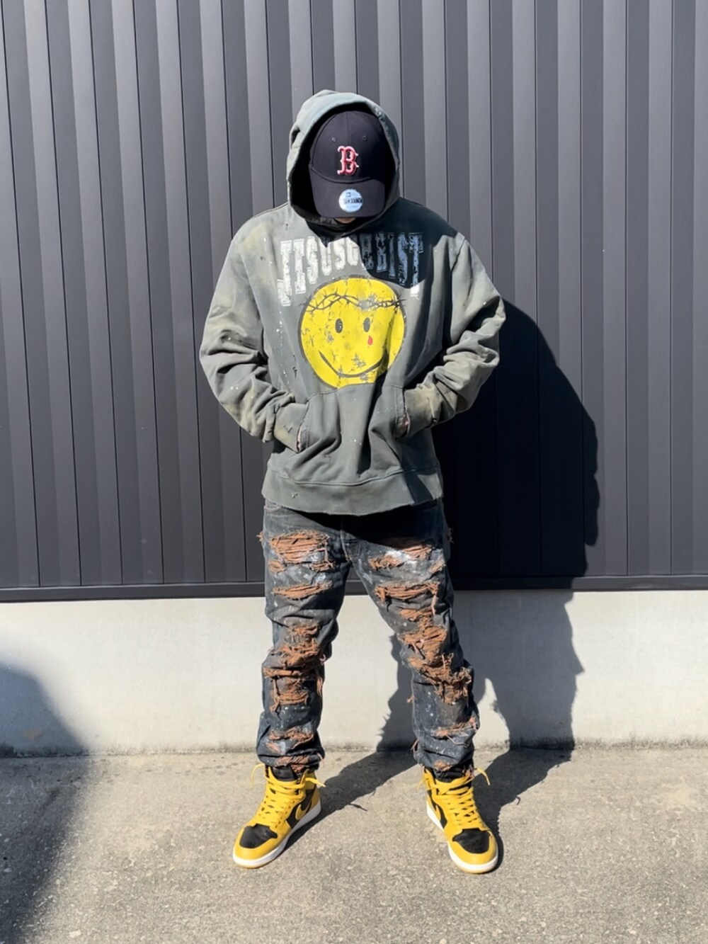 グリーン系のパーカー、ブルー系のデニムパンツ、イエロー系のスニーカーを着用したメンズの秋コーディネートの2枚目の写真