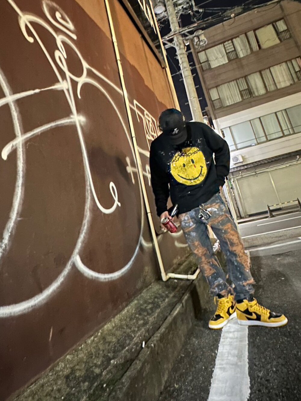 ブラック系のTシャツ/カットソー、ブルー系のデニムパンツ、イエロー系のスニーカーを着用したメンズの秋コーディネートの3枚目の写真