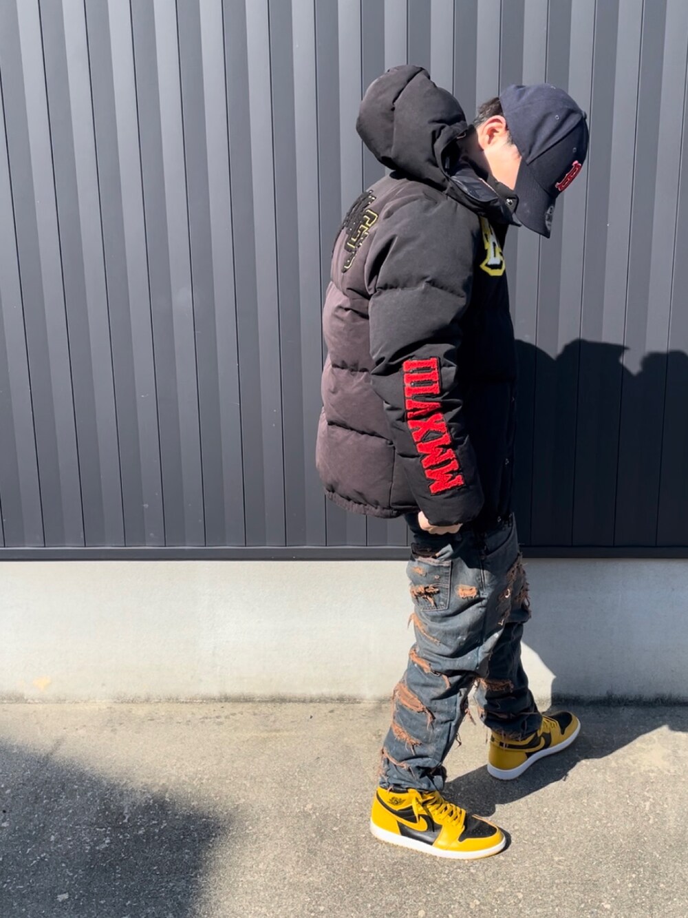 ブラック系のダウンジャケット/コート、ブラック系のTシャツ/カットソー、ブルー系のデニムパンツを着用したメンズの秋コーディネートの2枚目の写真