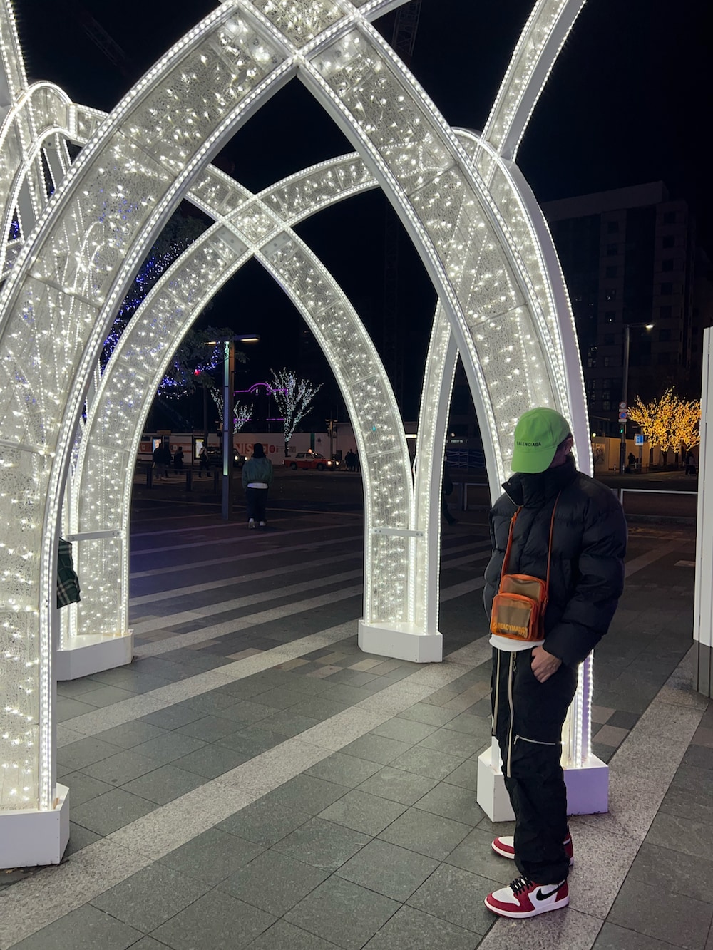 ブラック系のダウンジャケット/コート、オレンジ系のショルダーバッグ、ブラック系のカーゴパンツを着用したメンズの冬コーディネートの3枚目の写真