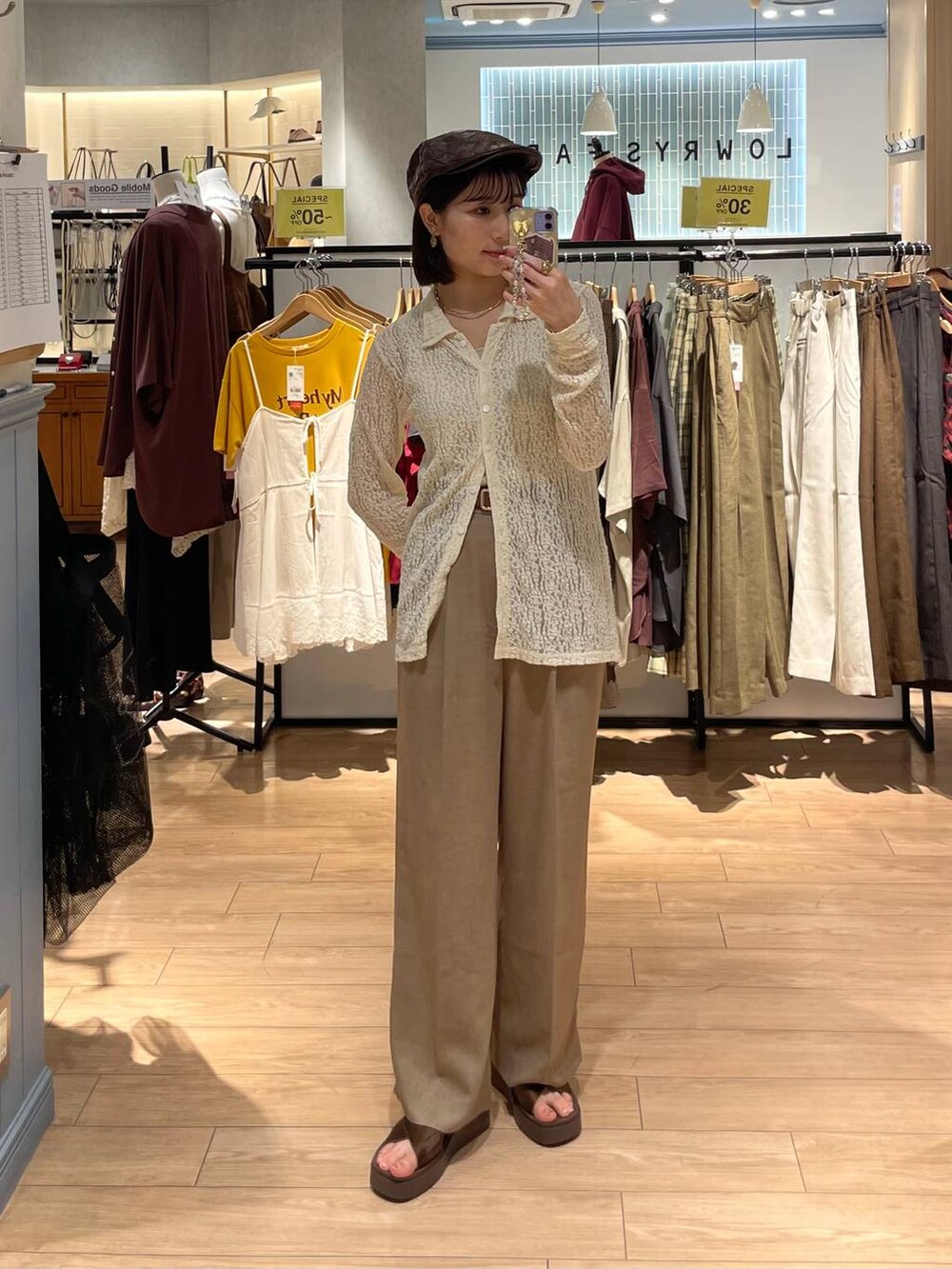 ブラウン系のサンダル、ゴールド系のタンクトップ、ベージュ系のスラックスを着用したレディースの秋コーディネートの3枚目の写真