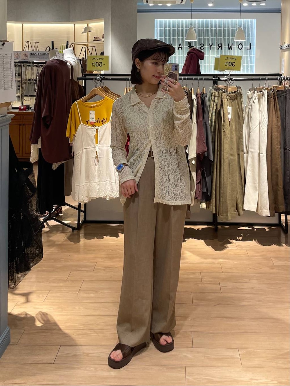 ブラウン系のサンダル、ゴールド系のタンクトップ、ベージュ系のスラックスを着用したレディースの秋コーディネートの4枚目の写真