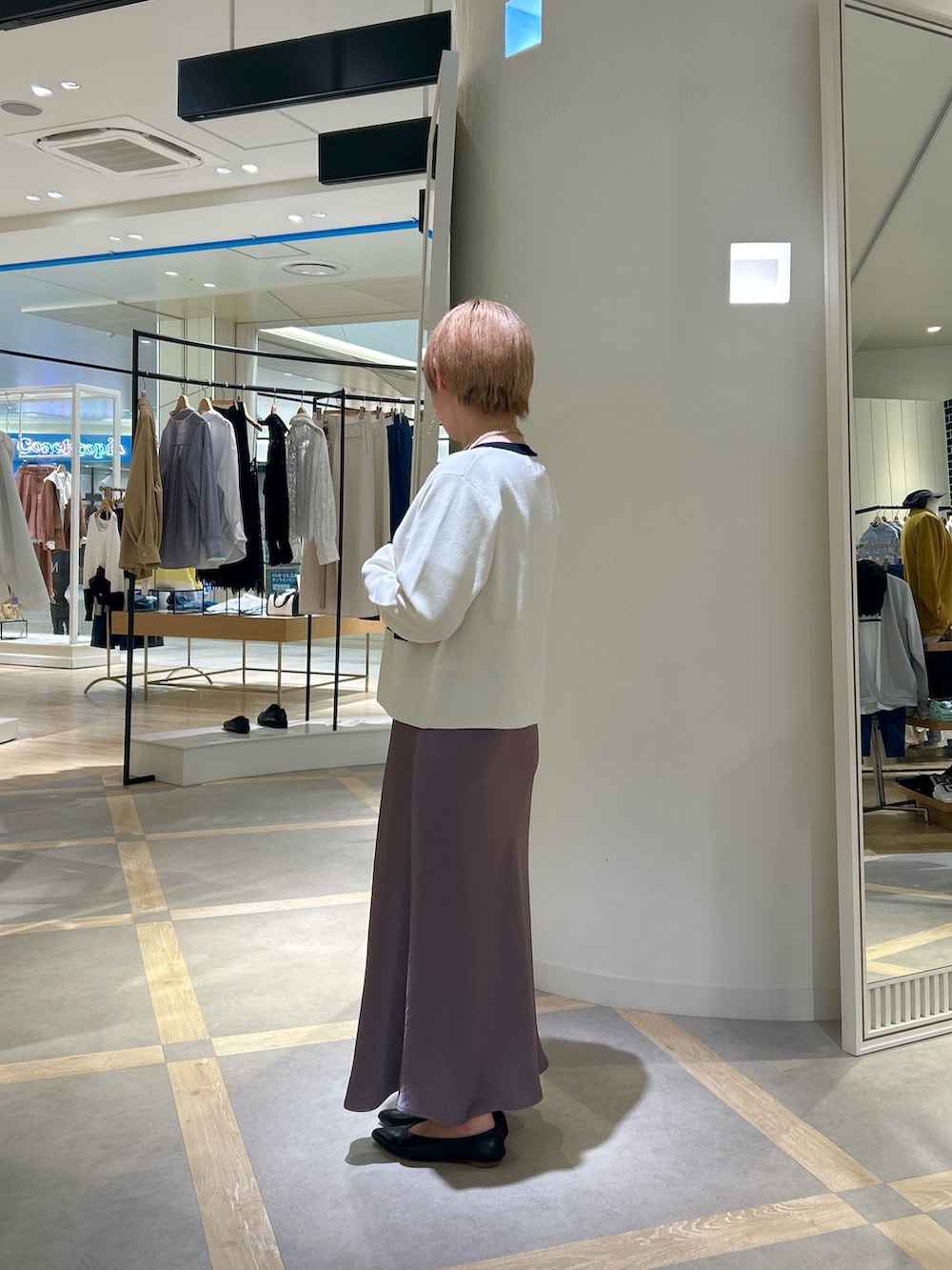 ブルー系のTシャツ/カットソー、グリーン系のスカート、ホワイト系のカーディガン/ボレロを着用したレディースの春コーディネートの3枚目の写真