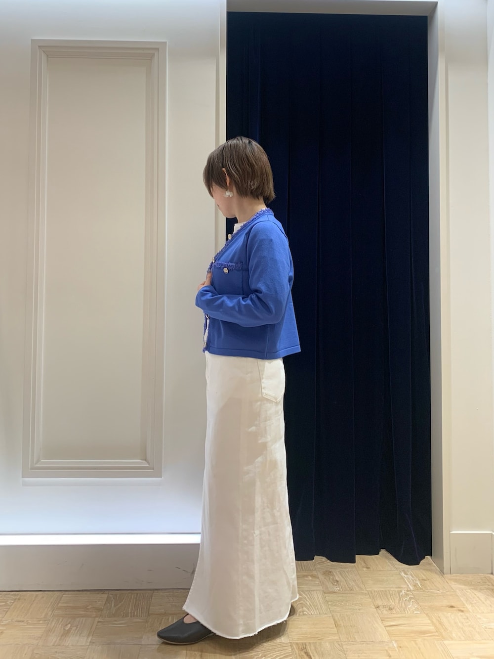 ホワイト系のTシャツ/カットソー、ブルー系のカーディガン/ボレロ、ホワイト系のデニムスカートを着用したレディースの春コーディネートの3枚目の写真