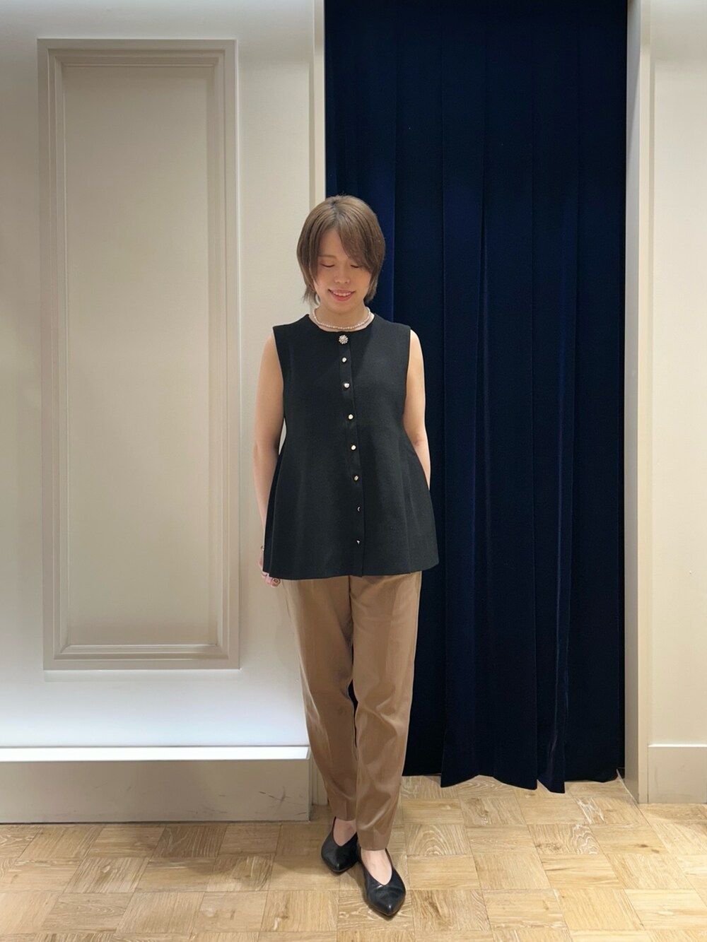 ブラック系のベスト、ブラック系のショルダーバッグ、イエロー系のその他パンツを着用したレディースの秋コーディネートの3枚目の写真