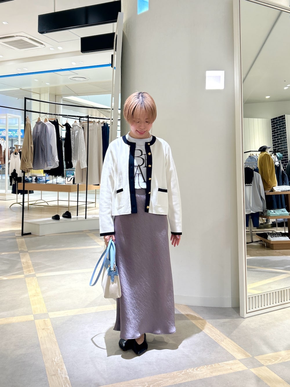 ブルー系のTシャツ/カットソー、グリーン系のスカート、ホワイト系のカーディガン/ボレロを着用したレディースの春コーディネートの2枚目の写真