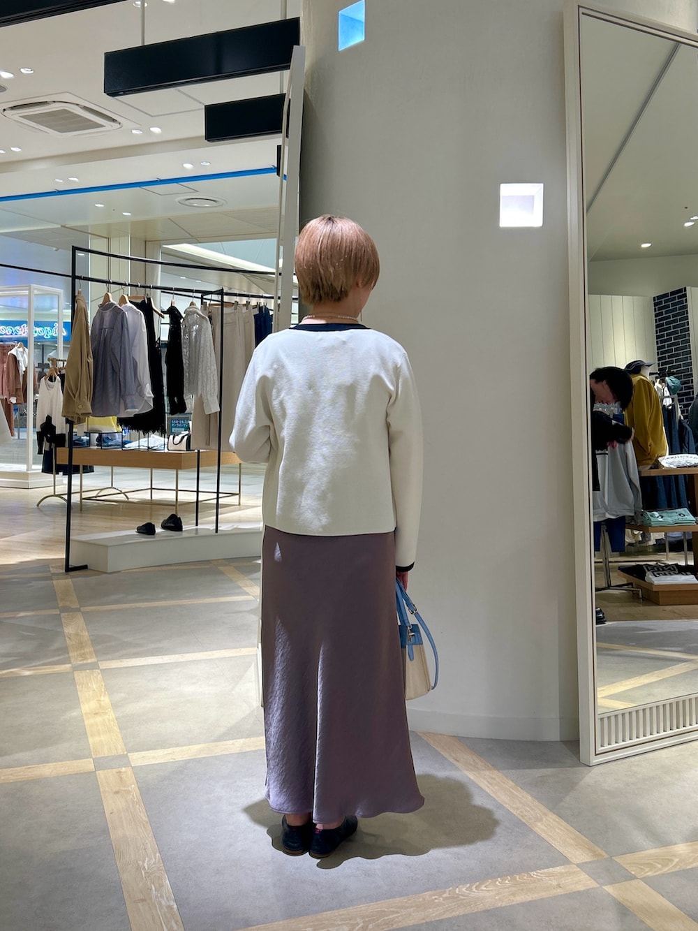 ブルー系のTシャツ/カットソー、グリーン系のスカート、ホワイト系のカーディガン/ボレロを着用したレディースの春コーディネートの4枚目の写真