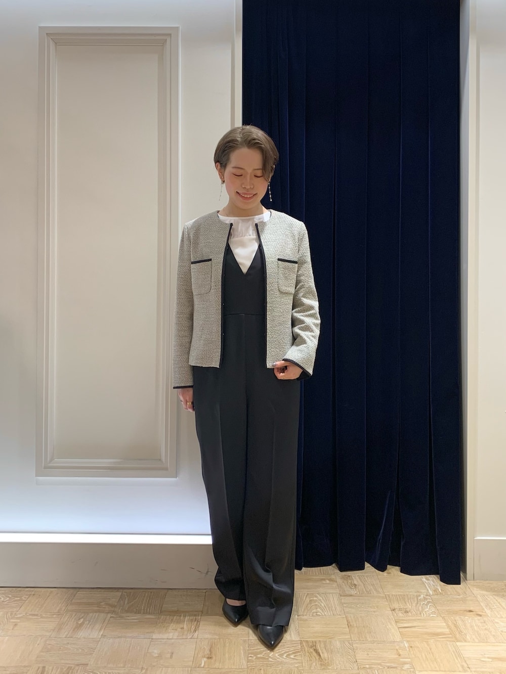 ブラック系のショルダーバッグ、ブルー系のつなぎ/オールインワン、ベージュ系のノーカラージャケットを着用したレディースの春コーディネートの2枚目の写真