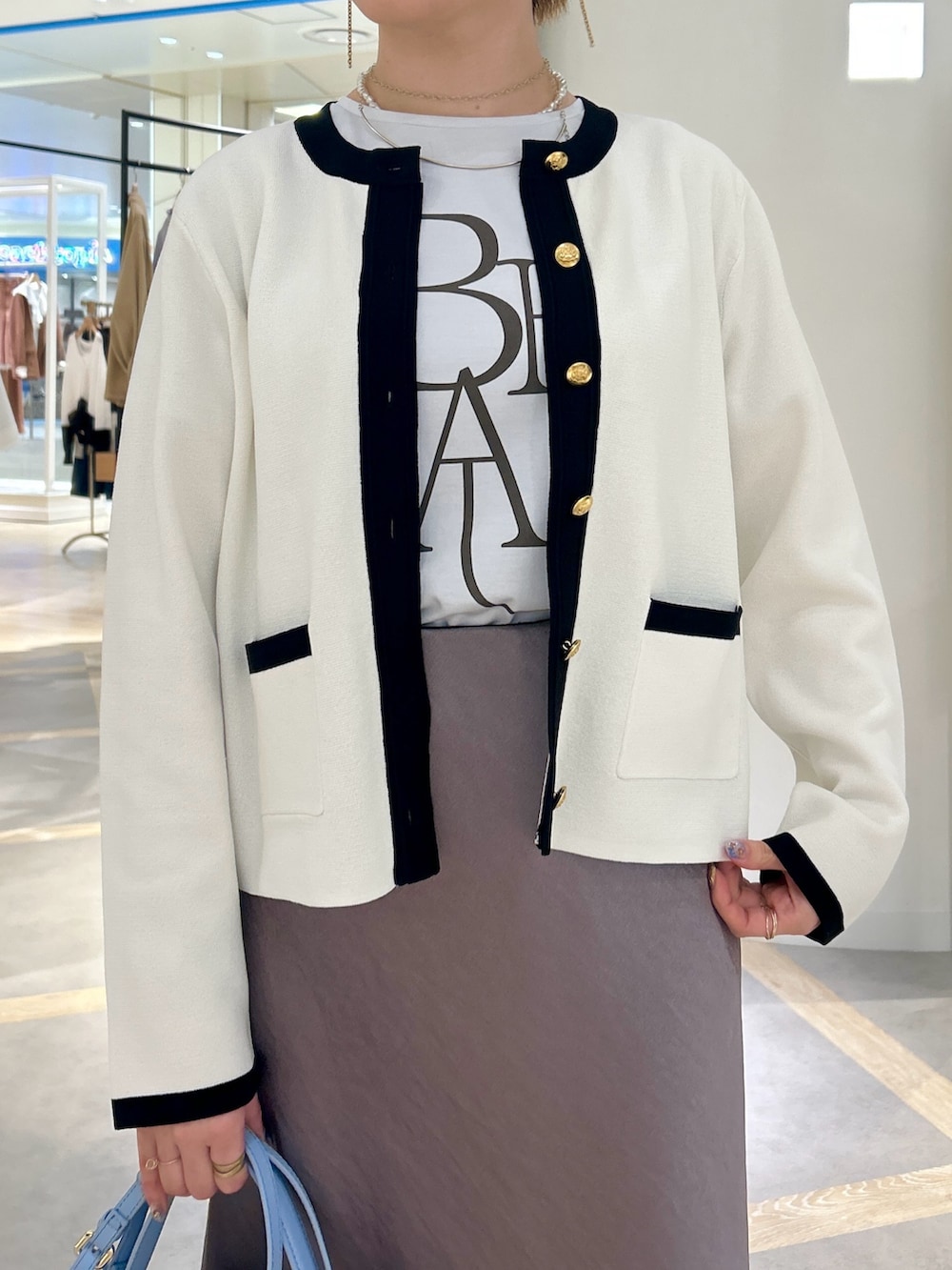 ブルー系のTシャツ/カットソー、グリーン系のスカート、ホワイト系のカーディガン/ボレロを着用したレディースの春コーディネートの5枚目の写真