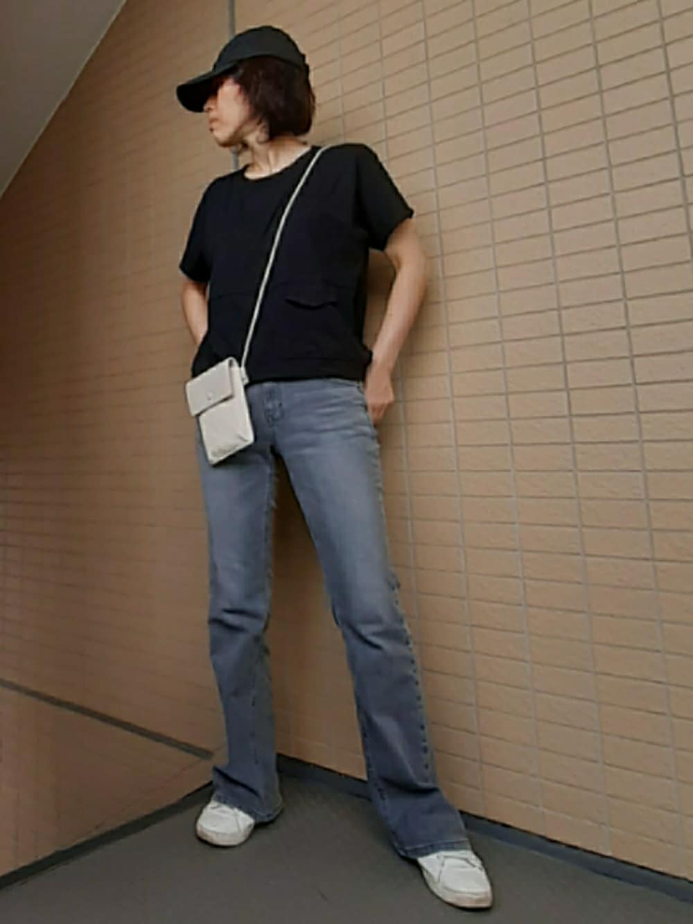 ホワイト系のショルダーバッグ、グレー系のデニムパンツ、ブラック系のTシャツ/カットソーを着用したレディースの夏コーディネートの2枚目の写真