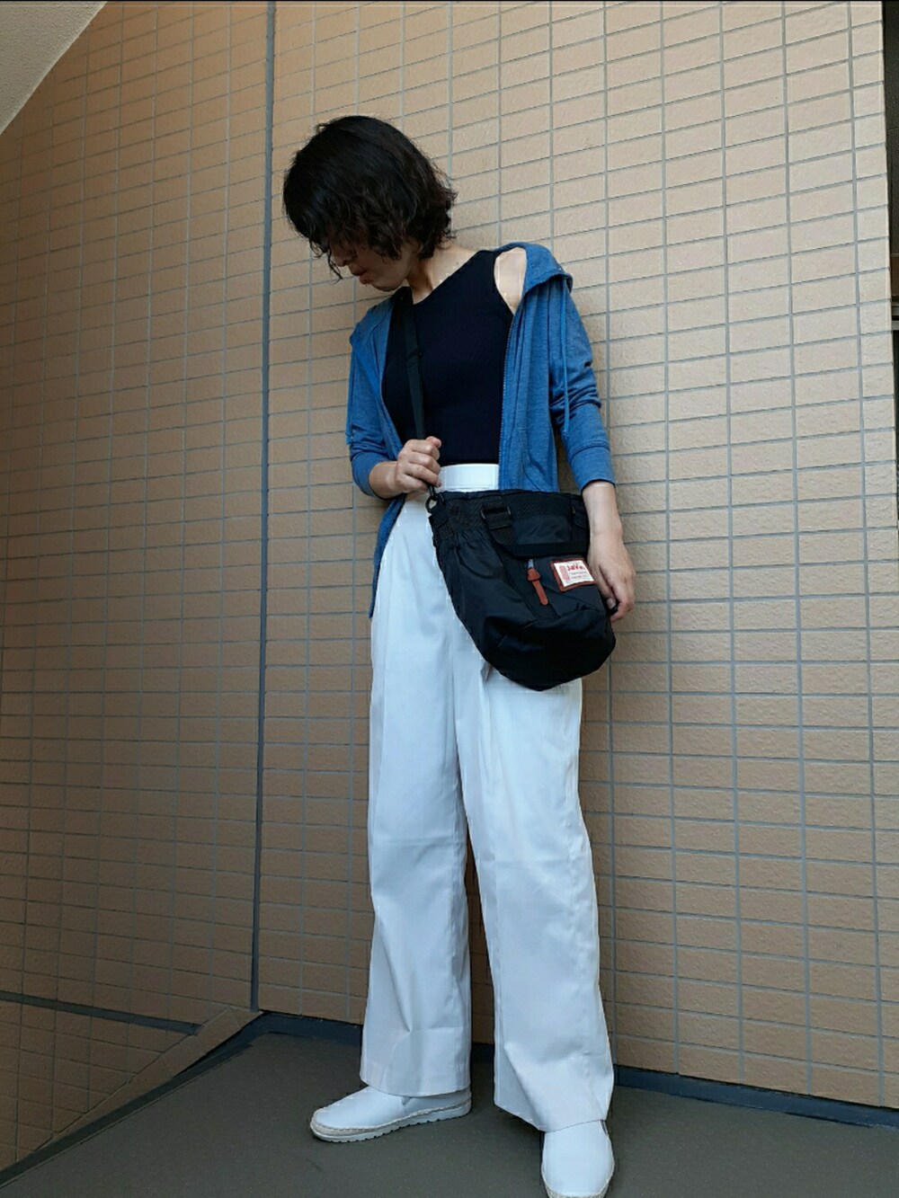 ホワイト系のその他パンツ、ホワイト系のスリッポン、ブラック系のショルダーバッグを着用したレディースの夏コーディネートの3枚目の写真