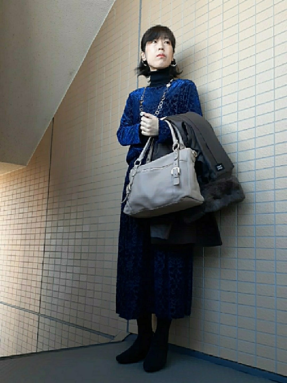 ブルー系のスカート、ブラック系のパンプス、ブラウン系のジャケット/アウターを着用したレディースの冬コーディネートの4枚目の写真