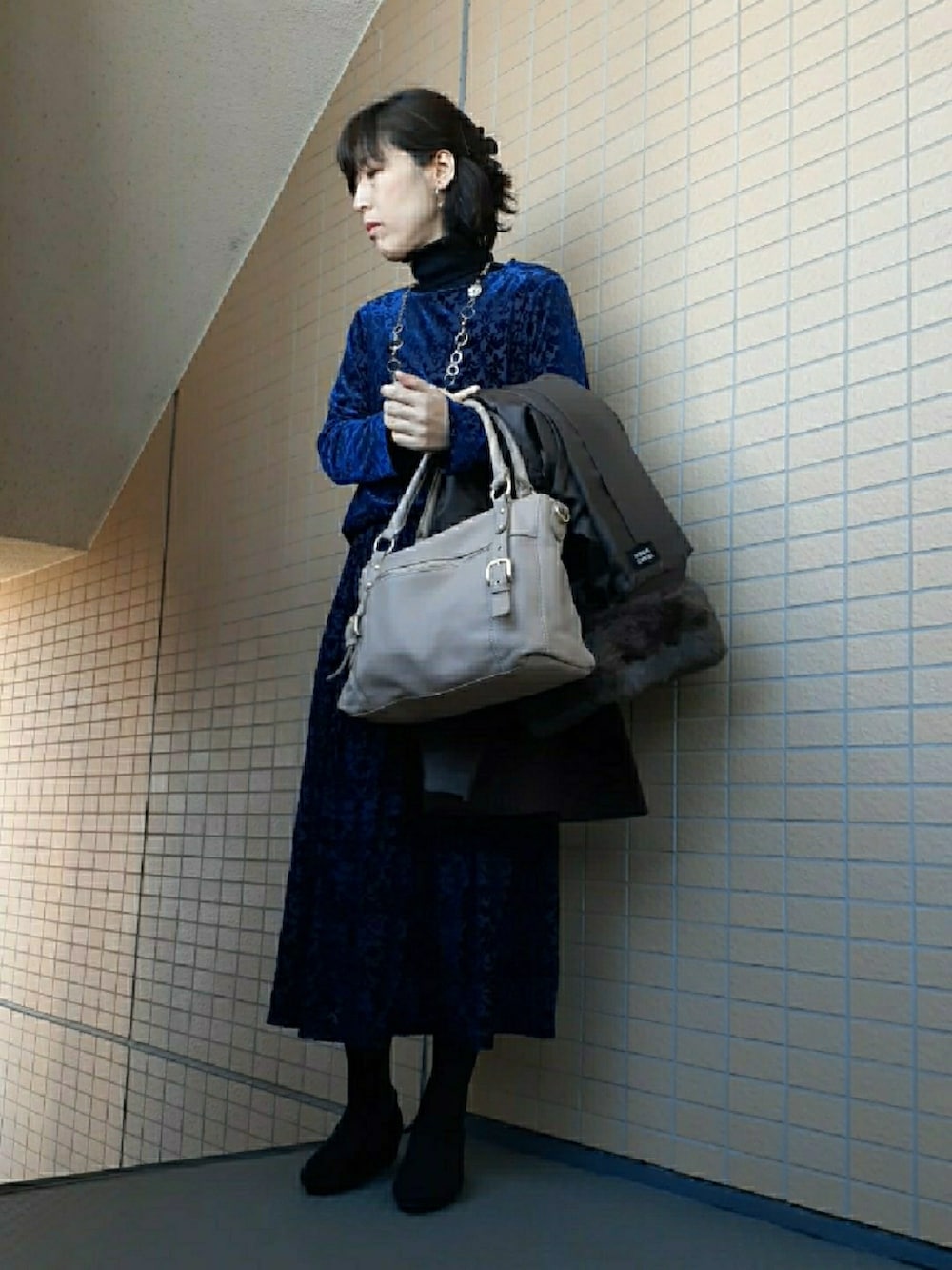 ブルー系のスカート、ブラック系のパンプス、ブラウン系のジャケット/アウターを着用したレディースの冬コーディネートの5枚目の写真