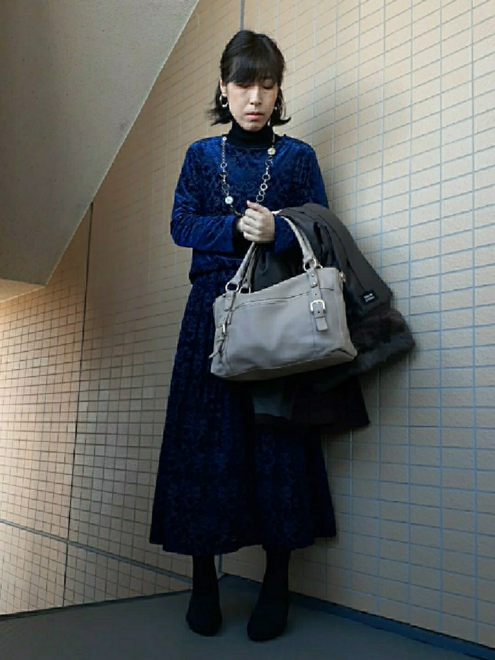 ブルー系のスカート、ブラック系のパンプス、ブラウン系のジャケット/アウターを着用したレディースの冬コーディネートの3枚目の写真