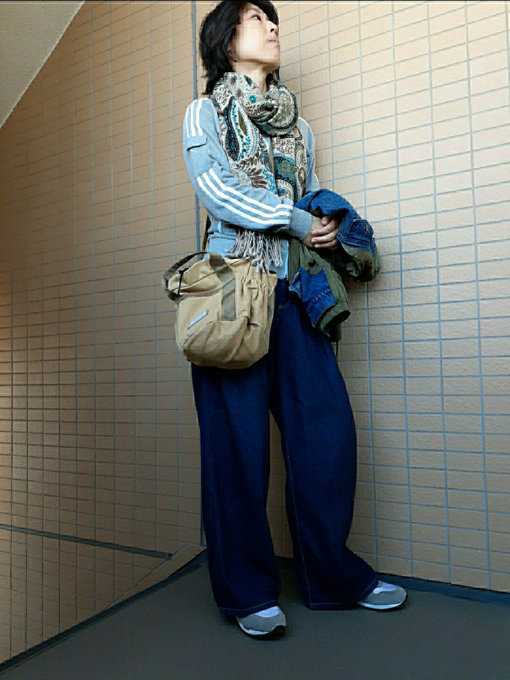 ベージュ系のショルダーバッグ、ブルー系のデニムパンツ、グレー系のスニーカーを着用したレディースの秋コーディネートの2枚目の写真