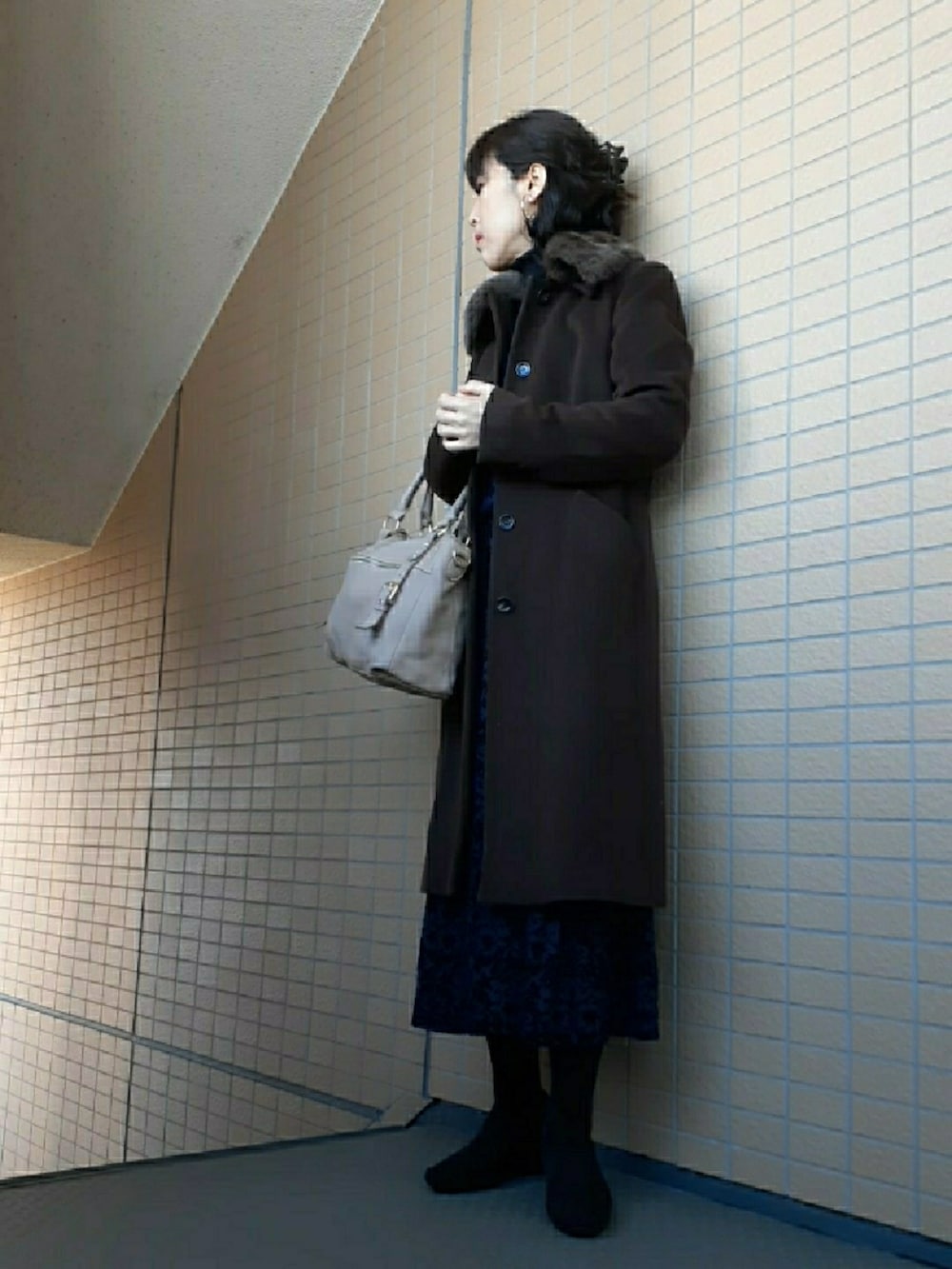 ブルー系のスカート、ブラック系のパンプス、ブラウン系のジャケット/アウターを着用したレディースの冬コーディネートの2枚目の写真