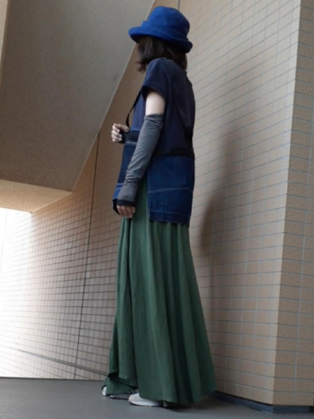 ブルー系のタンクトップ、ブラック系のショルダーバッグ、ホワイト系のスニーカーを着用したレディースの夏コーディネートの3枚目の写真