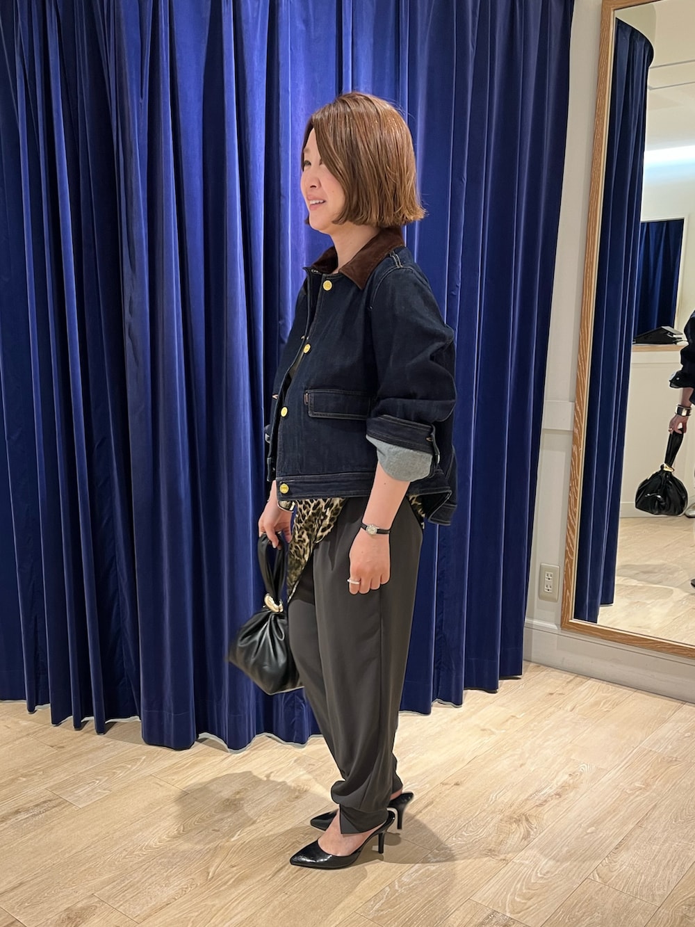 ブルー系のデニムジャケット、ブラック系のショルダーバッグ、グレー系のその他パンツを着用したレディースの夏コーディネートの5枚目の写真