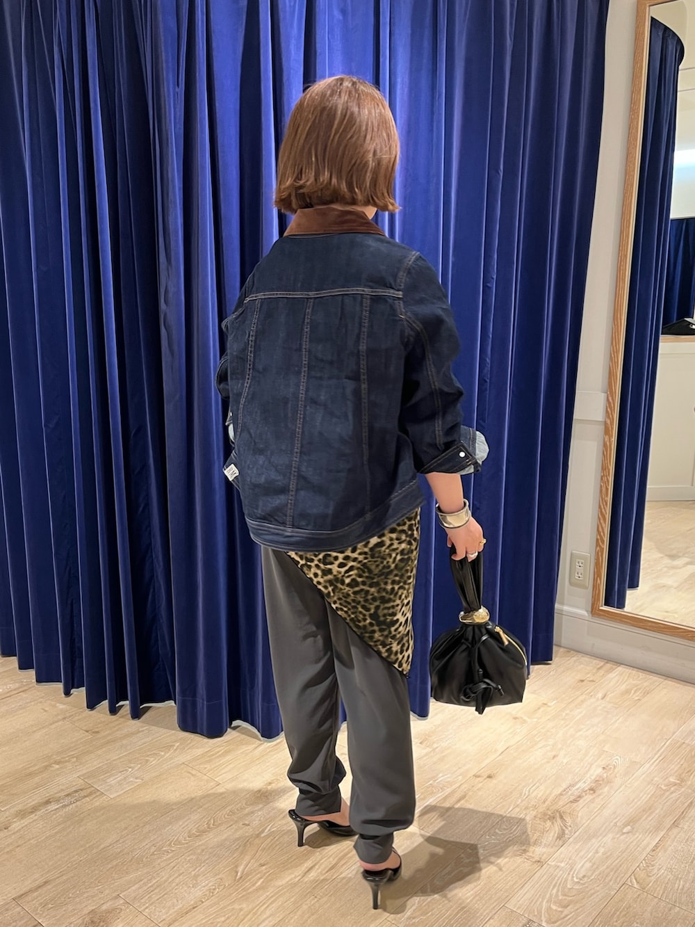 ブルー系のデニムジャケット、ブラック系のショルダーバッグ、グレー系のその他パンツを着用したレディースの夏コーディネートの3枚目の写真