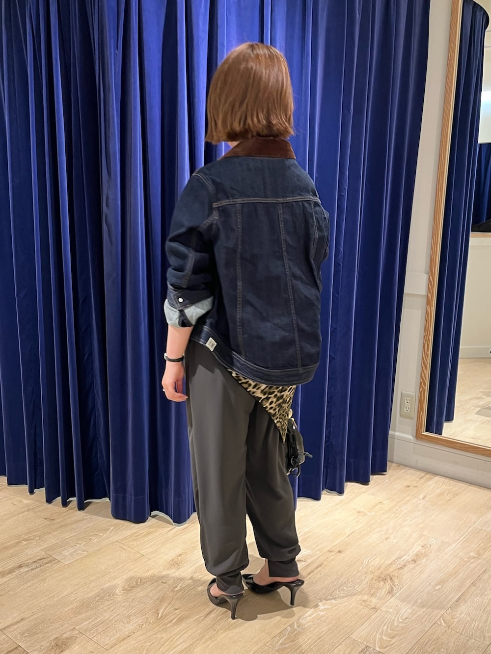 ブルー系のデニムジャケット、ブラック系のショルダーバッグ、グレー系のその他パンツを着用したレディースの夏コーディネートの4枚目の写真