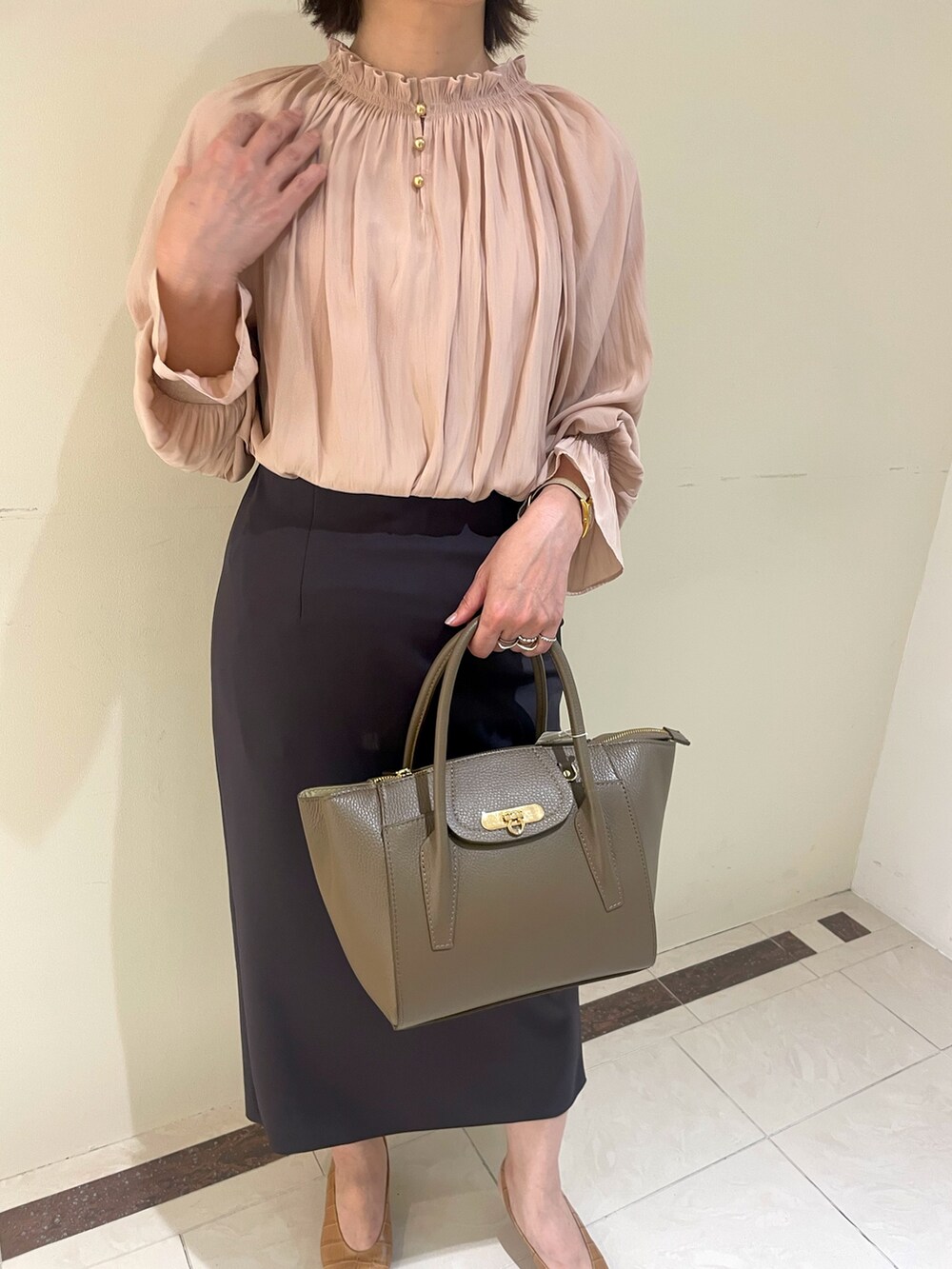 ホワイト系のスカート、ブラウン系のショルダーバッグ、イエロー系のシャツ/ブラウスを着用したレディースの秋コーディネートの5枚目の写真