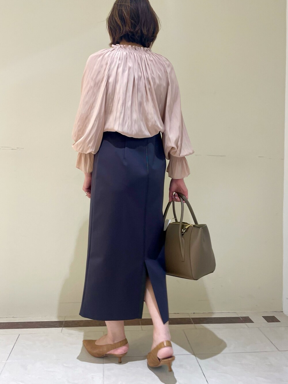 ホワイト系のスカート、ブラウン系のショルダーバッグ、イエロー系のシャツ/ブラウスを着用したレディースの秋コーディネートの7枚目の写真