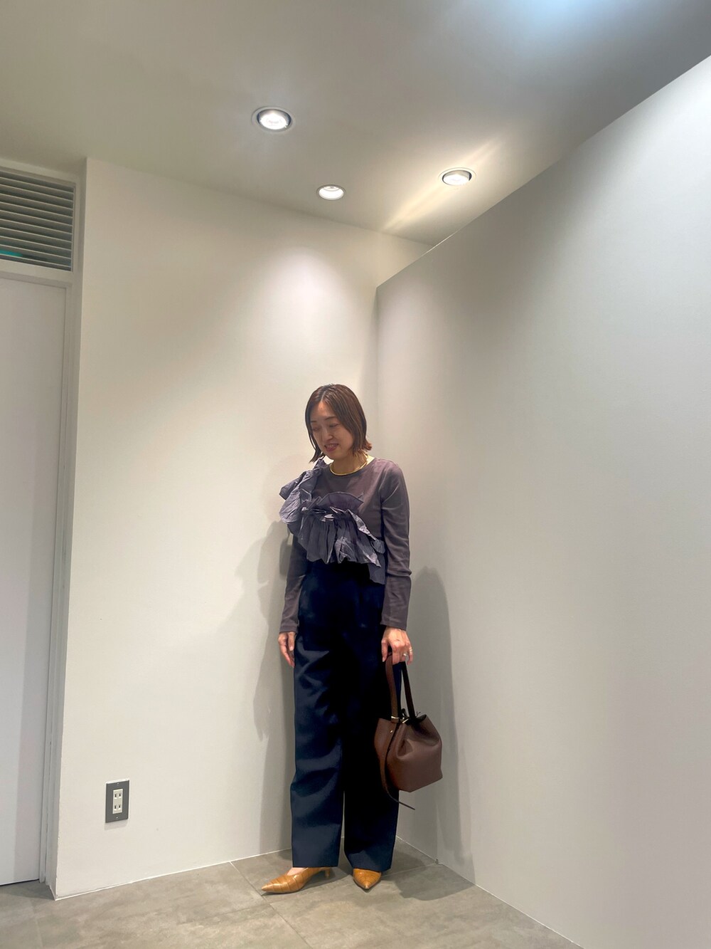 グレー系のTシャツ/カットソー、ブルー系のその他パンツ、ブラウン系のショルダーバッグを着用したレディースの秋コーディネートの3枚目の写真