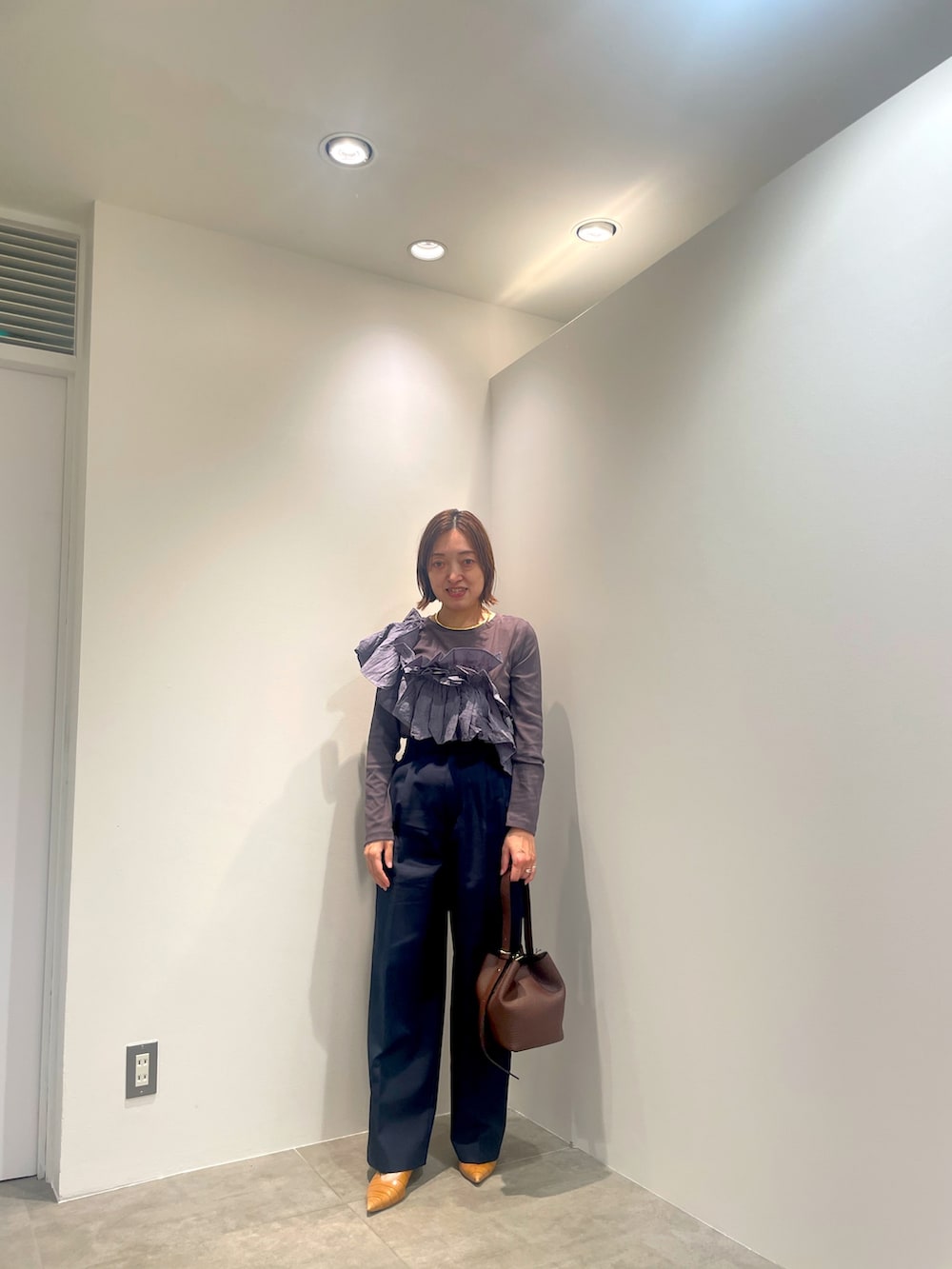 グレー系のTシャツ/カットソー、ブルー系のその他パンツ、ブラウン系のショルダーバッグを着用したレディースの秋コーディネートの2枚目の写真