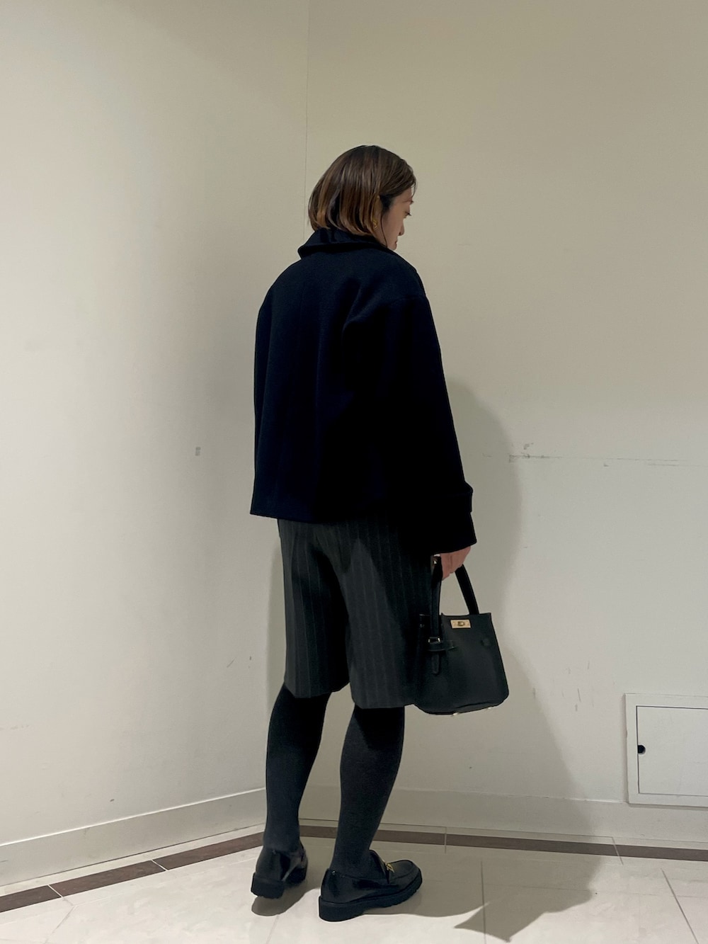 ブラック系のその他パンツ、ブルー系のピーコート、ピンク系のカーディガン/ボレロを着用したレディースの冬コーディネートの4枚目の写真
