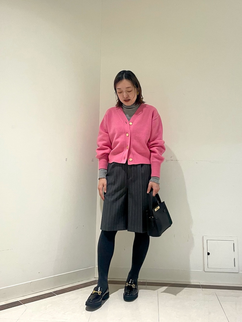 ブラック系のその他パンツ、ブルー系のピーコート、ピンク系のカーディガン/ボレロを着用したレディースの冬コーディネートの7枚目の写真