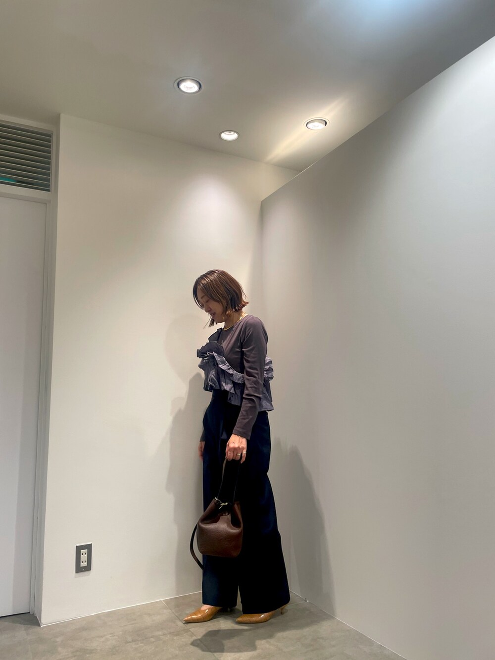 グレー系のTシャツ/カットソー、ブルー系のその他パンツ、ブラウン系のショルダーバッグを着用したレディースの秋コーディネートの4枚目の写真