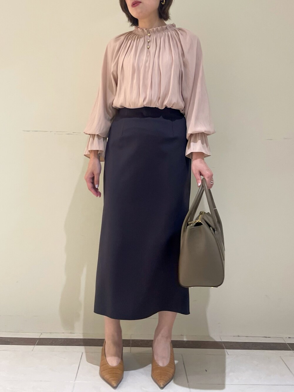 ホワイト系のスカート、ブラウン系のショルダーバッグ、イエロー系のシャツ/ブラウスを着用したレディースの秋コーディネートの4枚目の写真