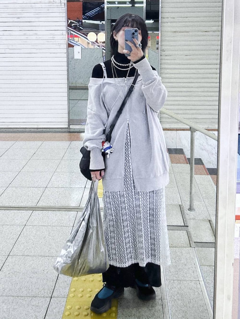 ブラック系のニット/セーター、ブラック系のショルダーバッグ、グレー系のスウェットを着用したレディースの春コーディネートの2枚目の写真