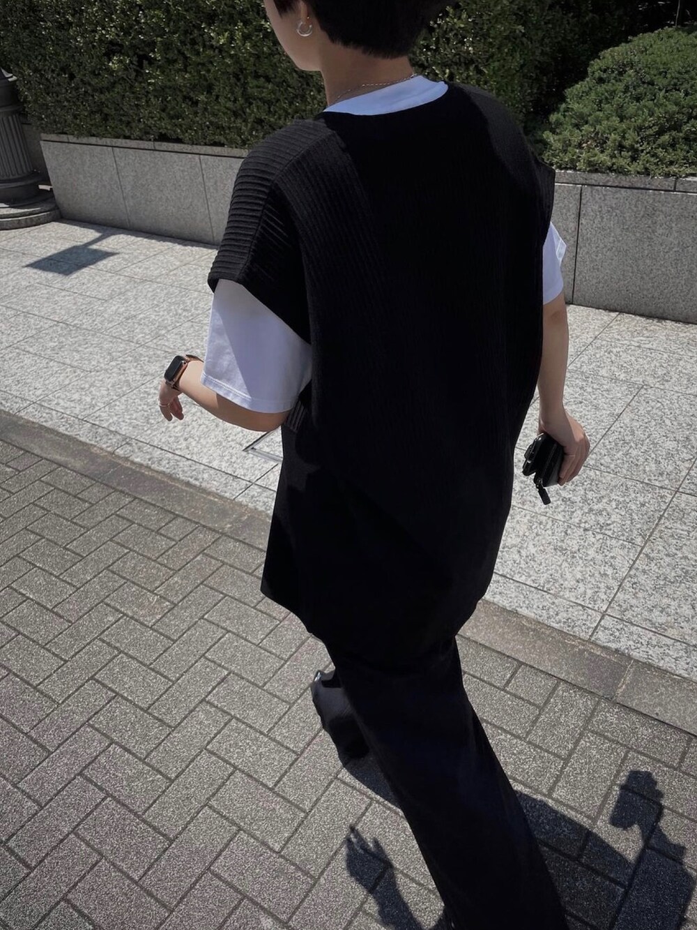 ブラック系のベストを着用したレディースの夏コーディネートの2枚目の写真