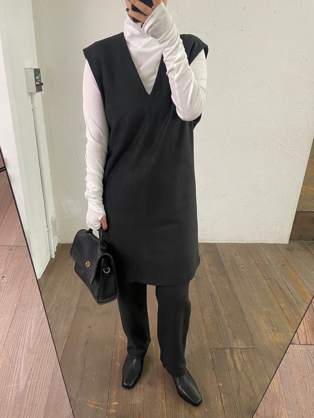 ブラック系のベスト、ブラック系のスラックス、ホワイト系のTシャツ/カットソーを着用したレディースの秋コーディネートの2枚目の写真