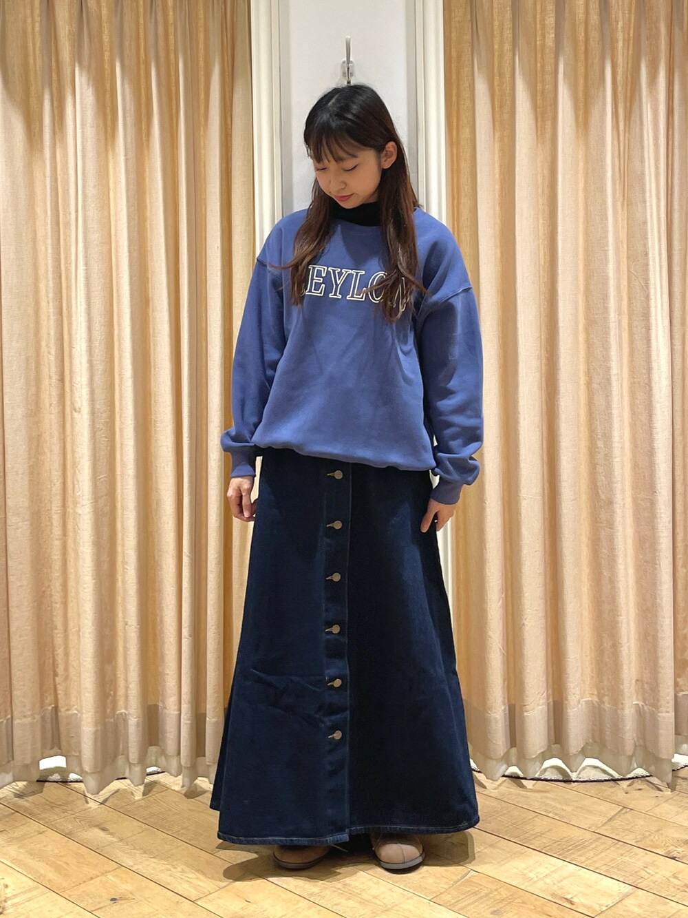 ブルー系のスカート、ブルー系のTシャツ/カットソー、ベージュ系のドレスシューズを着用したレディースの冬コーディネートの2枚目の写真