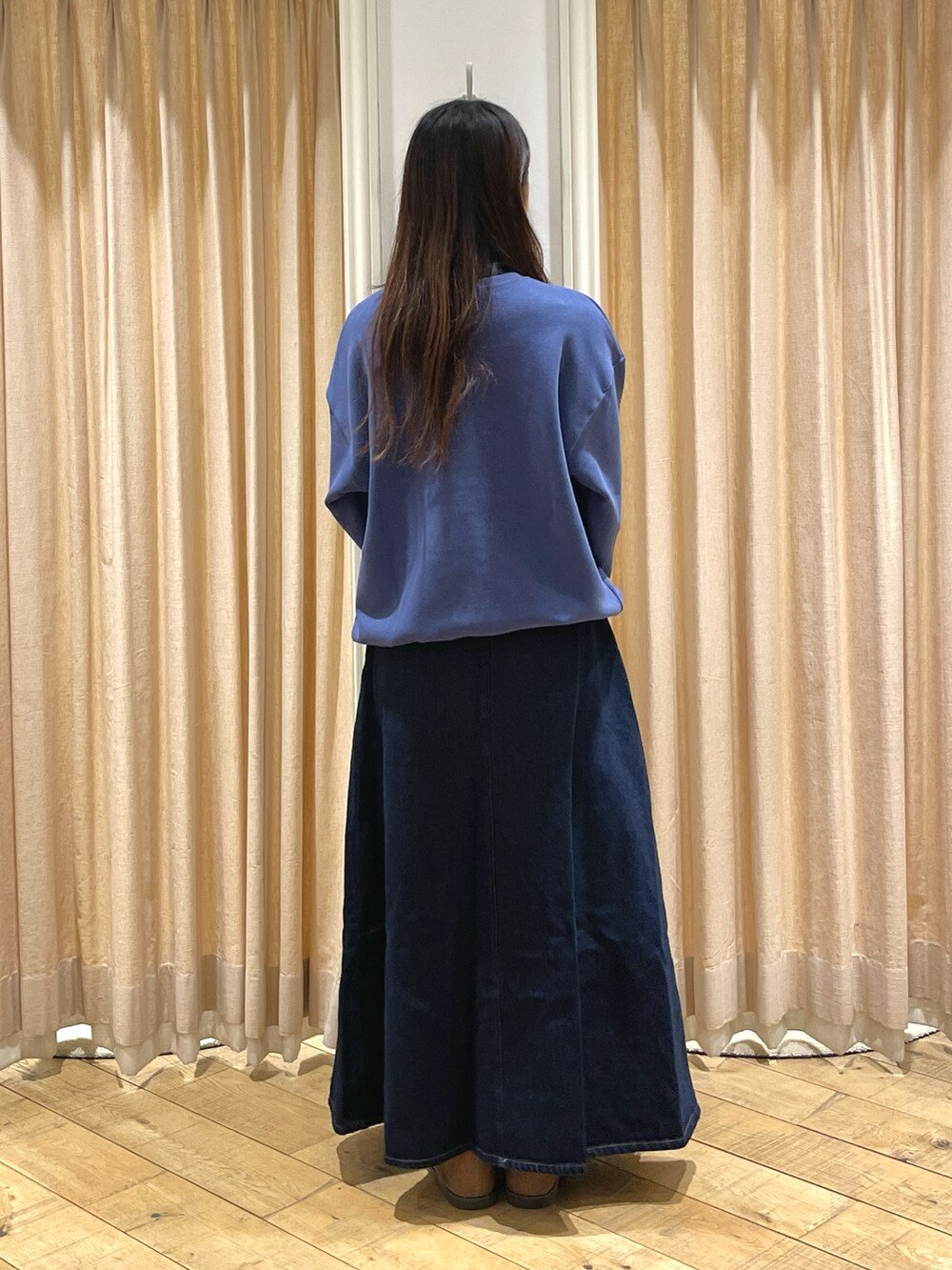 ブルー系のスカート、ブルー系のTシャツ/カットソー、ベージュ系のドレスシューズを着用したレディースの冬コーディネートの4枚目の写真