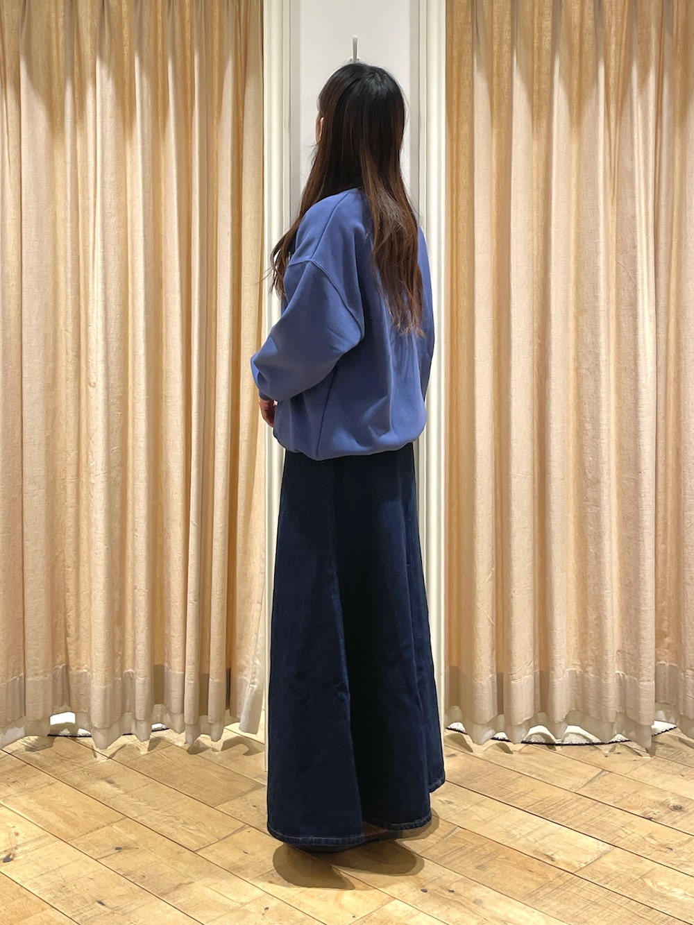 ブルー系のスカート、ブルー系のTシャツ/カットソー、ベージュ系のドレスシューズを着用したレディースの冬コーディネートの3枚目の写真