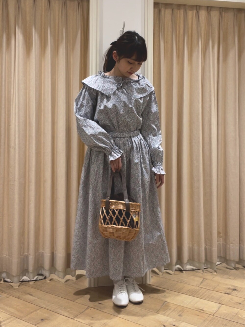 ブラウン系のハンドバッグ、ブルー系のシャツ/ブラウス、ブルー系のスカートを着用したレディースの冬コーディネートの2枚目の写真