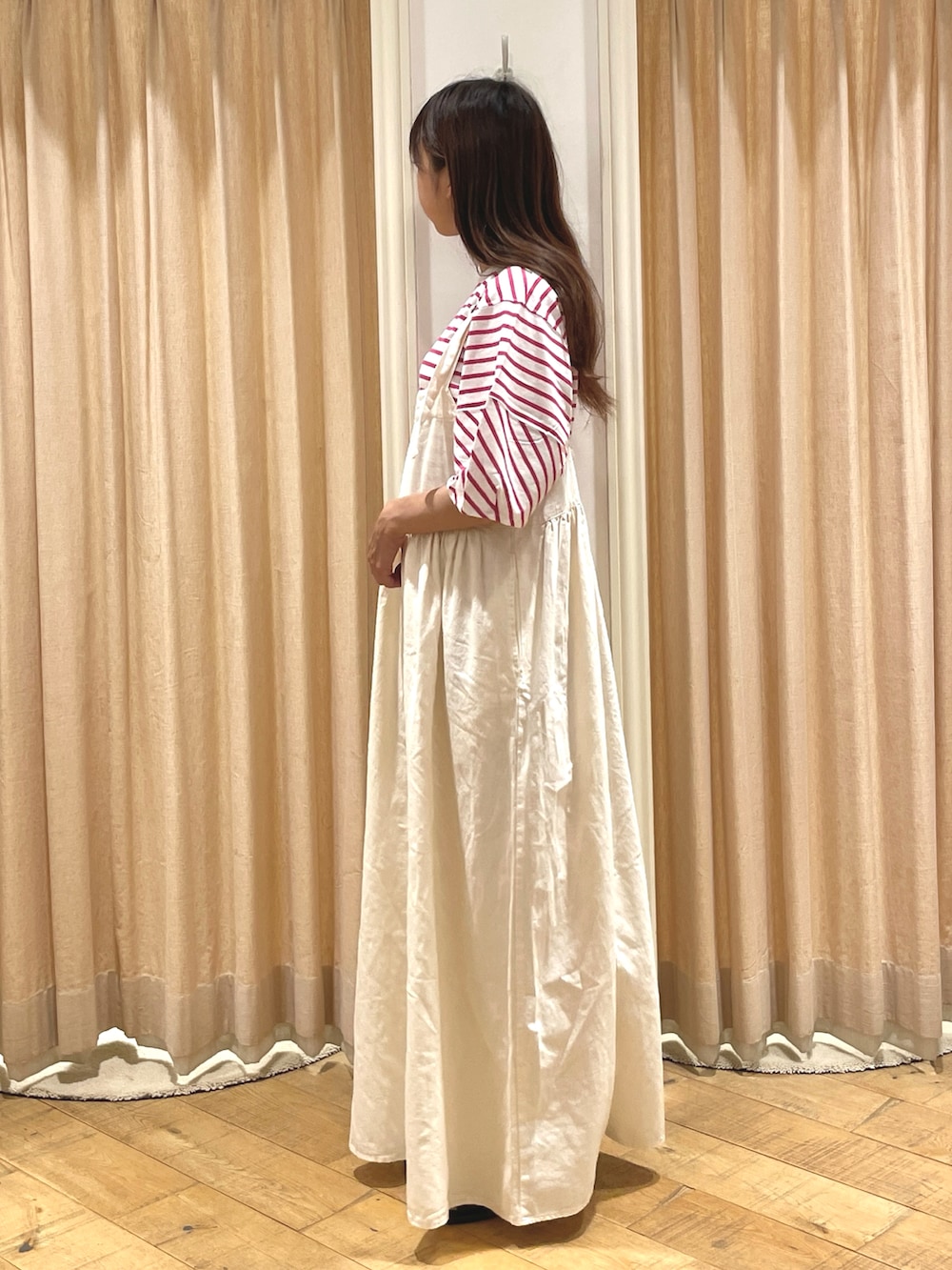 ホワイト系のワンピース、ピンク系のTシャツ/カットソー、ブラウン系のサンダルを着用したレディースの夏コーディネートの2枚目の写真