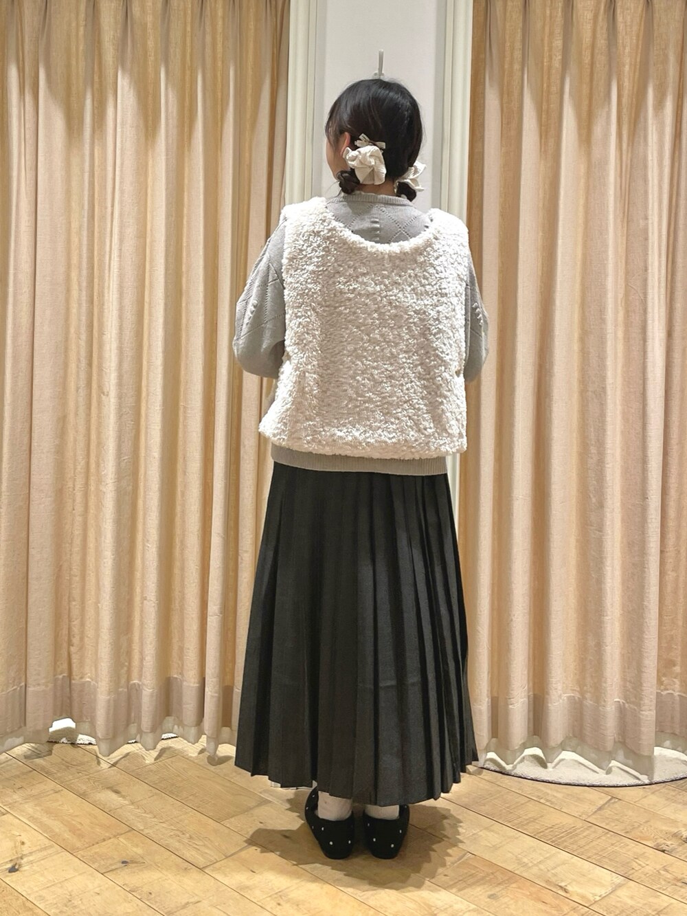 グレー系のスカート、グレー系のドレスシューズ、ブラウン系のニット/セーターを着用したレディースの秋コーディネートの3枚目の写真