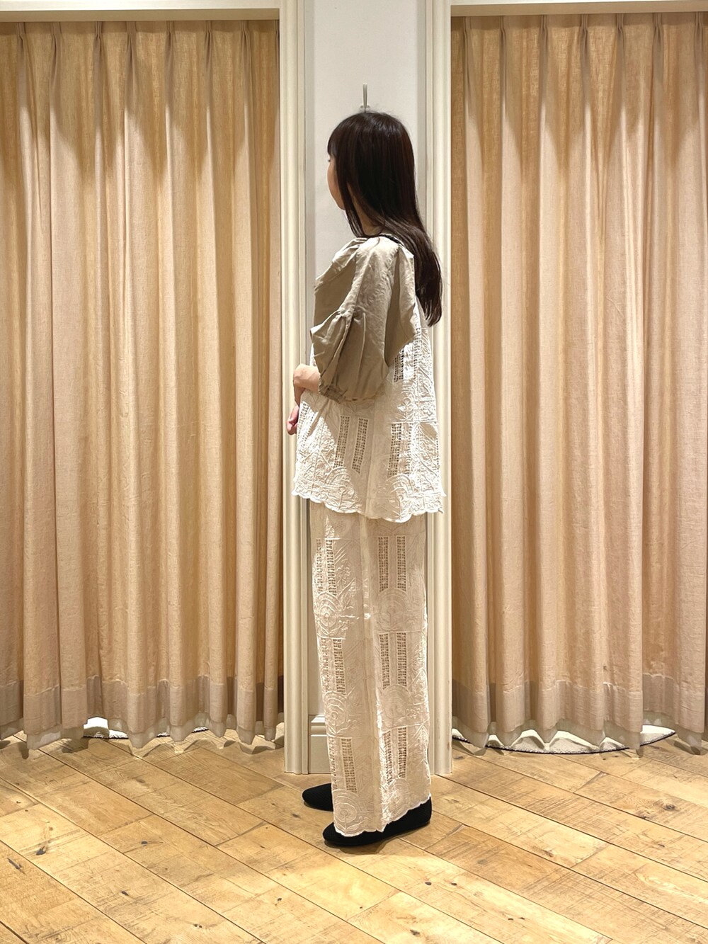 ブラック系のハンドバッグ、ブラック系のドレスシューズ、ベージュ系のシャツ/ブラウスを着用したレディースの春コーディネートの2枚目の写真