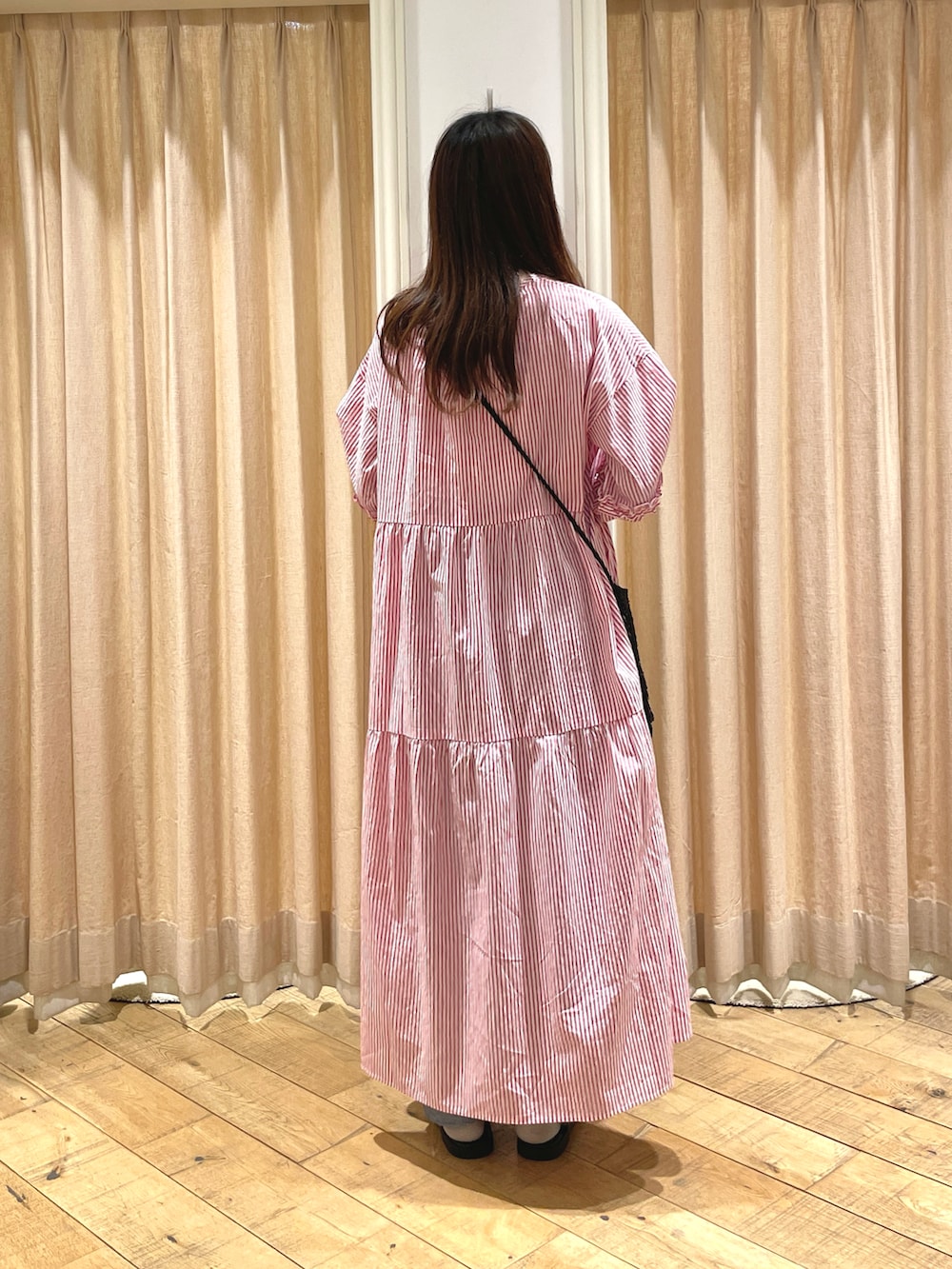 ブラック系のサンダル、ブラック系のハンドバッグ、レッド系のワンピースを着用したレディースの春コーディネートの3枚目の写真