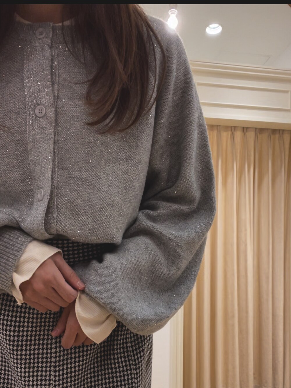 グレー系のカーディガン/ボレロ、ホワイト系のTシャツ/カットソー、ホワイト系のスカートを着用したレディースの冬コーディネートの3枚目の写真