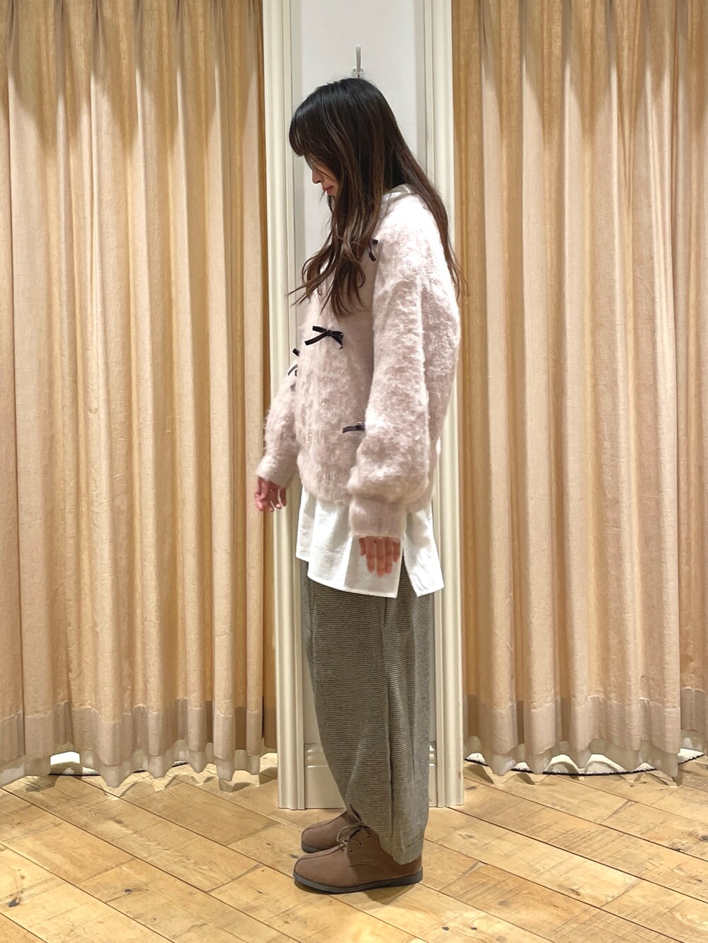 ホワイト系のニット/セーター、ブラック系のその他パンツ、ベージュ系のドレスシューズを着用したレディースの冬コーディネートの2枚目の写真