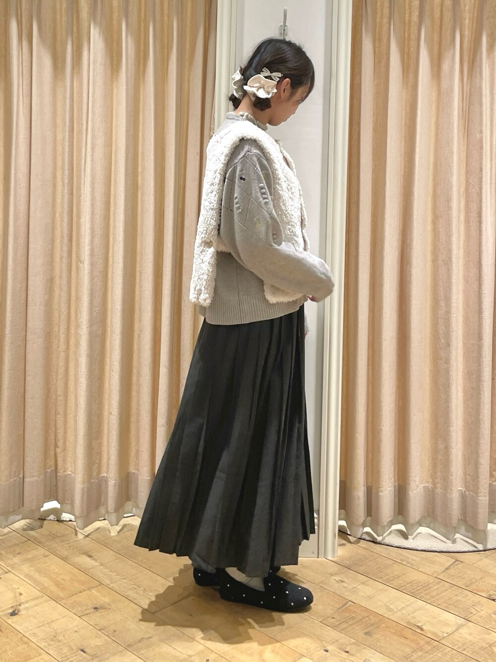 グレー系のスカート、グレー系のドレスシューズ、ブラウン系のニット/セーターを着用したレディースの秋コーディネートの2枚目の写真