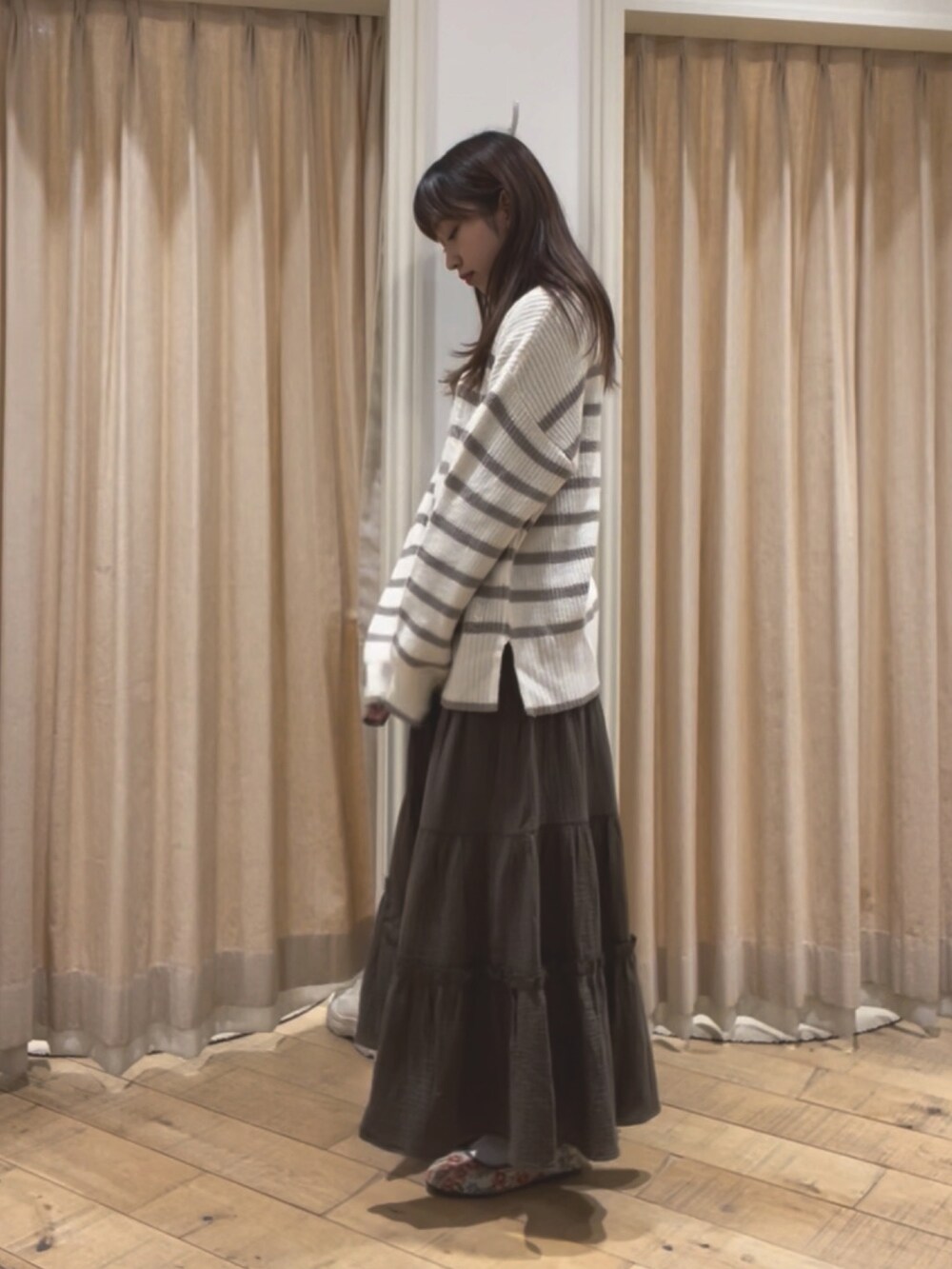 ベージュ系のニット/セーター、ベージュ系のカーディガン/ボレロ、グリーン系のスカートを着用したレディースの冬コーディネートの3枚目の写真